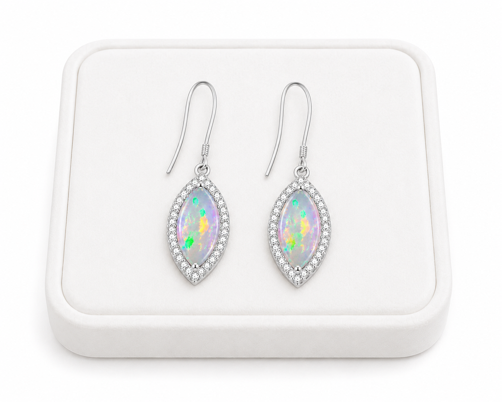 Natural fire opal marquise dangle earrings displayed on white jewelry tray