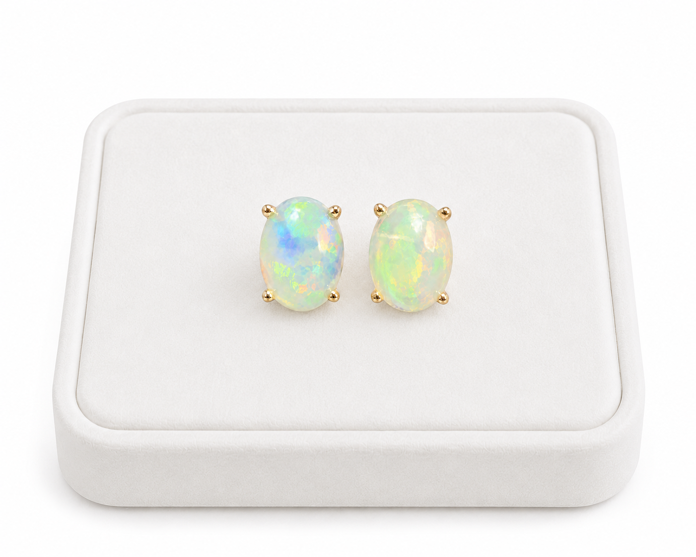 Natural 6x8mm fire opal stud earrings displayed on white jewelry tray