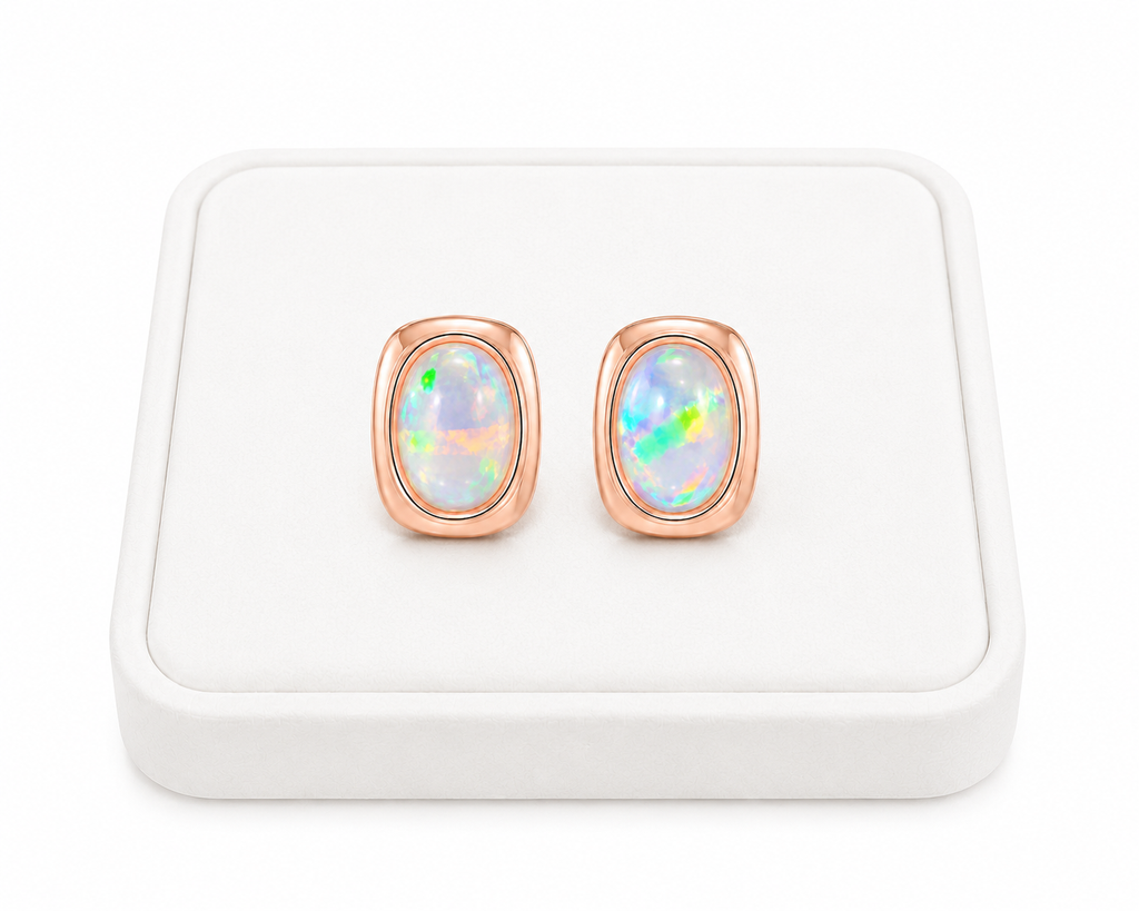 5x7mm fire opal earrings displayed at an angle on a luxury white jewelry tray