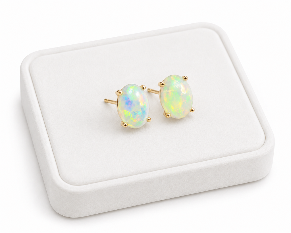 Natural 6x8mm fire opal stud earrings displayed on white jewelry tray