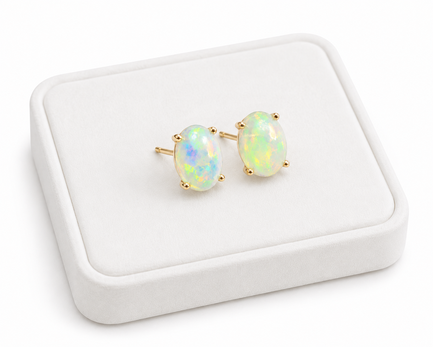 Natural 6x8mm fire opal stud earrings displayed on white jewelry tray