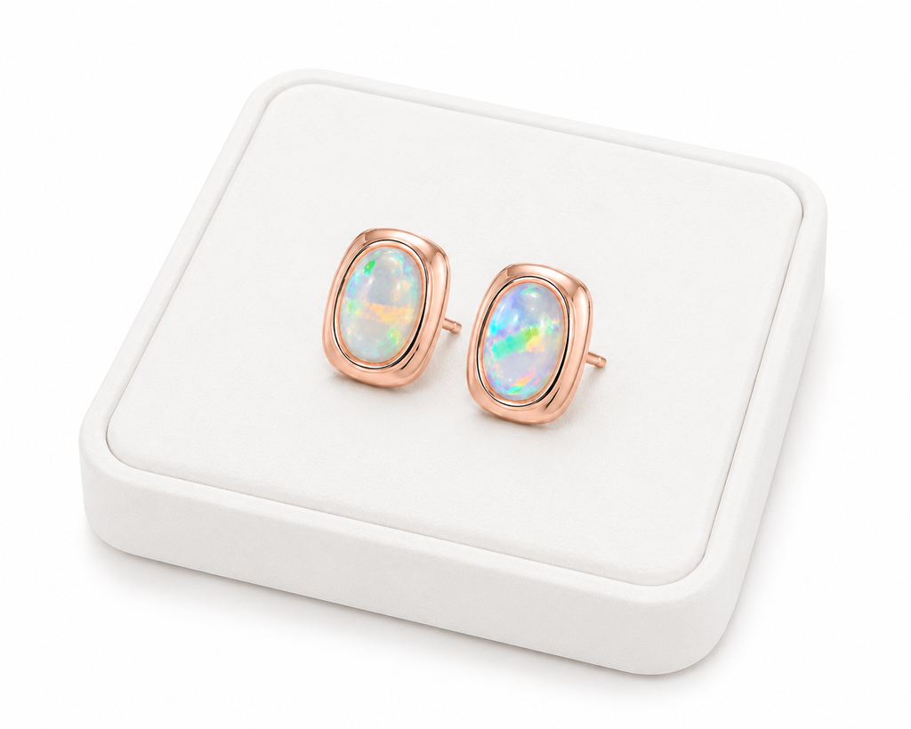 5x7mm fire opal earrings displayed at an angle on a luxury white jewelry tray