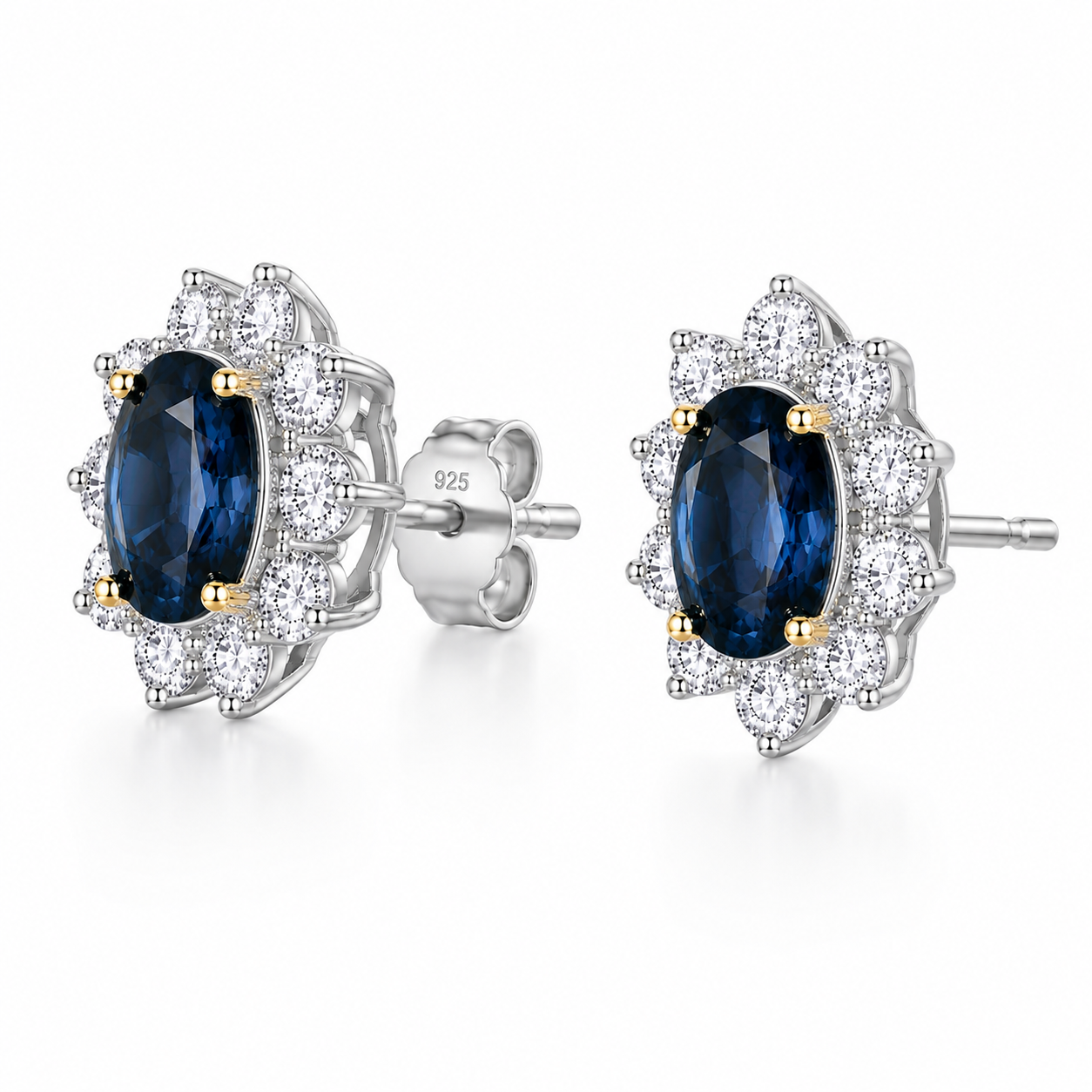 Natural 5x7mm oval London Blue Topaz halo stud earrings in platinum plated sterling silver with cubic zirconia on a white background.