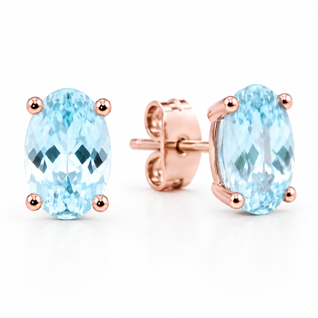 Macro close-up of genuine 4x6mm oval aquamarine earrings highlighting natural brilliance