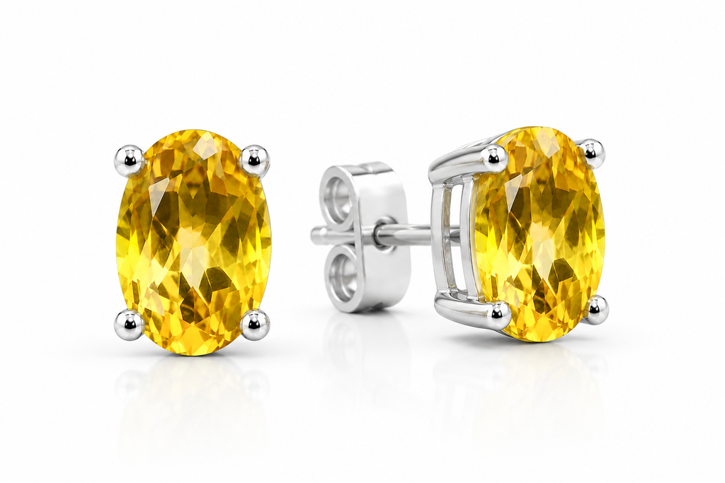 Macro close-up of natural 4x6mm oval citrine gemstone stud earrings showing brilliant facets and natural golden-yellow color