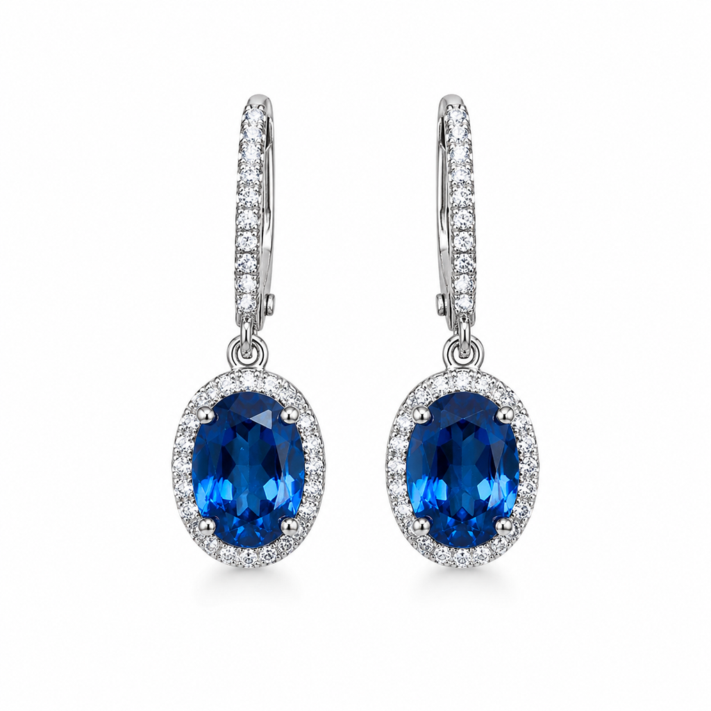 Natural 6x8mm oval London Blue Topaz halo dangle earrings in solid 925 sterling silver with secure leverback closures, available in platinum, yellow gold, or rose gold finish, presented in a PHIMSERA gift box.