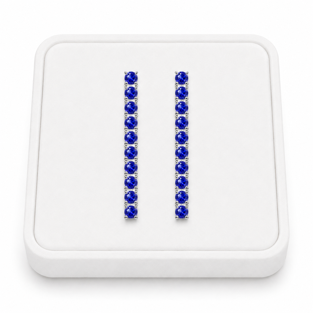 Phimsera natural sapphire dangle earrings displayed on a white velvet jewelry tray against a bright white background