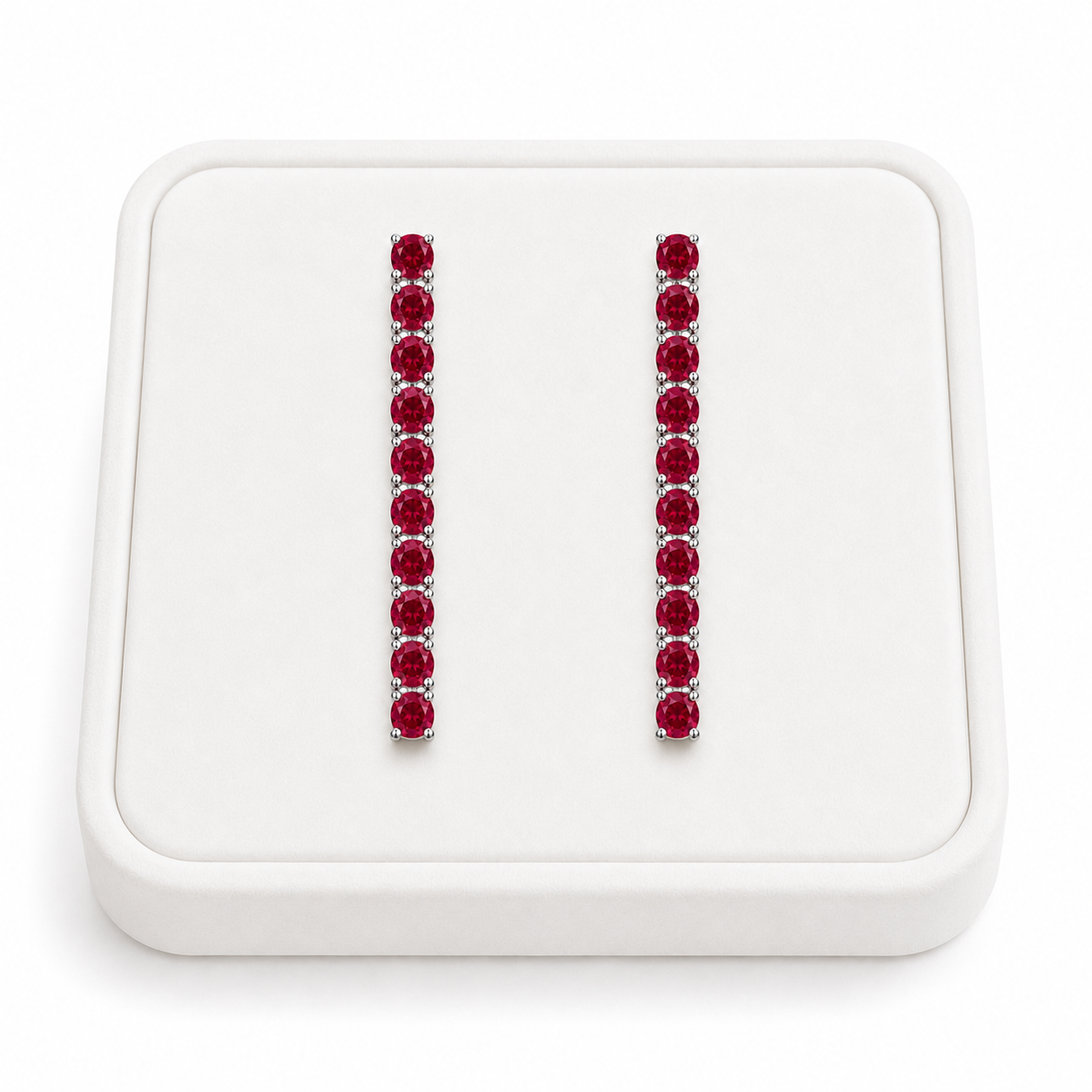 Phimsera natural ruby dangle earrings displayed on a white velvet jewelry tray against a bright white background