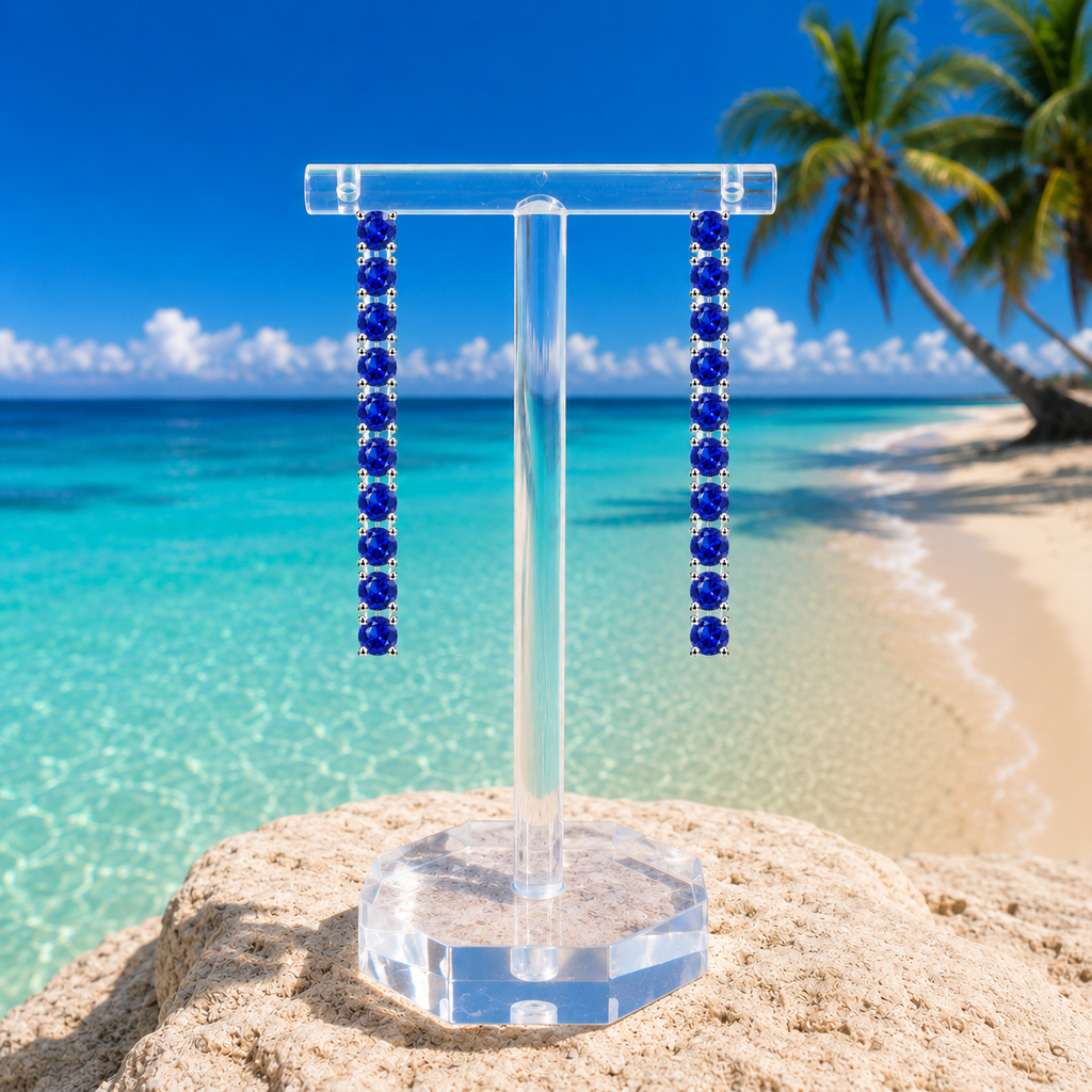 Phimsera natural blue sapphire dangle earrings styled in a bright beach lifestyle setting