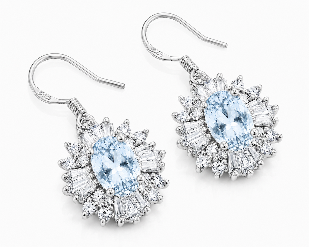 Sky Blue Topaz floral dangle earrings shown at an angle with pale blue oval gemstones, sparkling halos, and silver fishhooks
