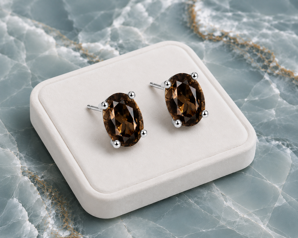 Natural 4x6mm oval smoky quartz stud earrings in 925 sterling silver on a blue marble background
