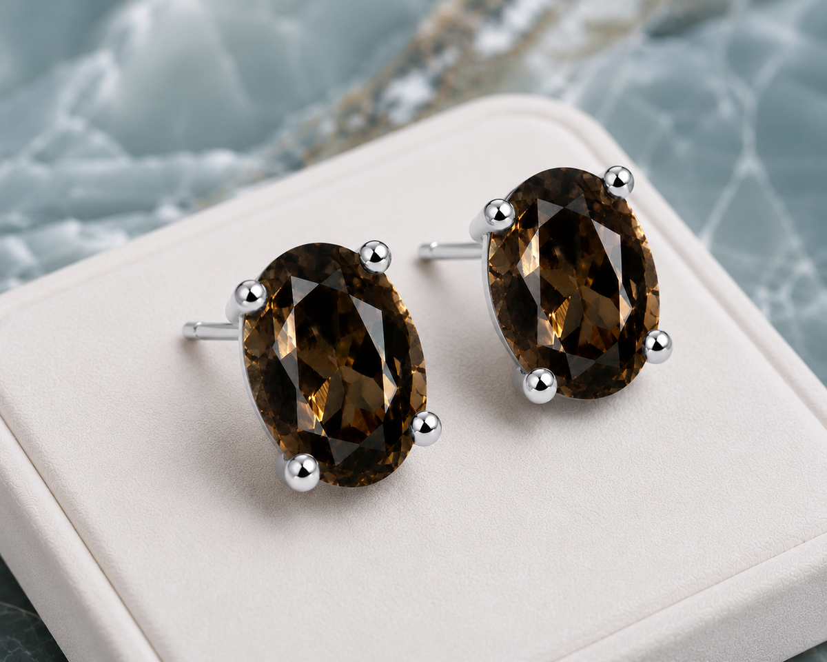 Natural 4x6mm oval smoky quartz stud earrings in 925 sterling silver on a blue marble background