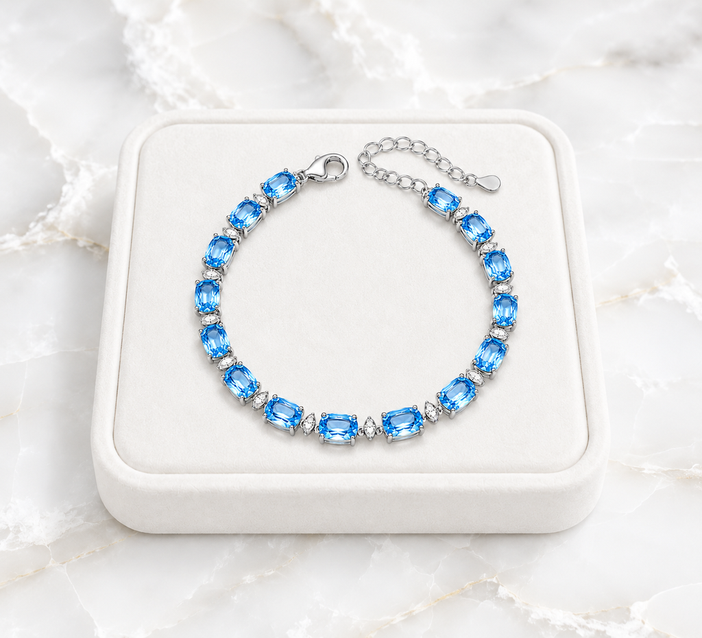 Swiss Blue Topaz bracelet displayed on an ivory jewelry tray over white marble