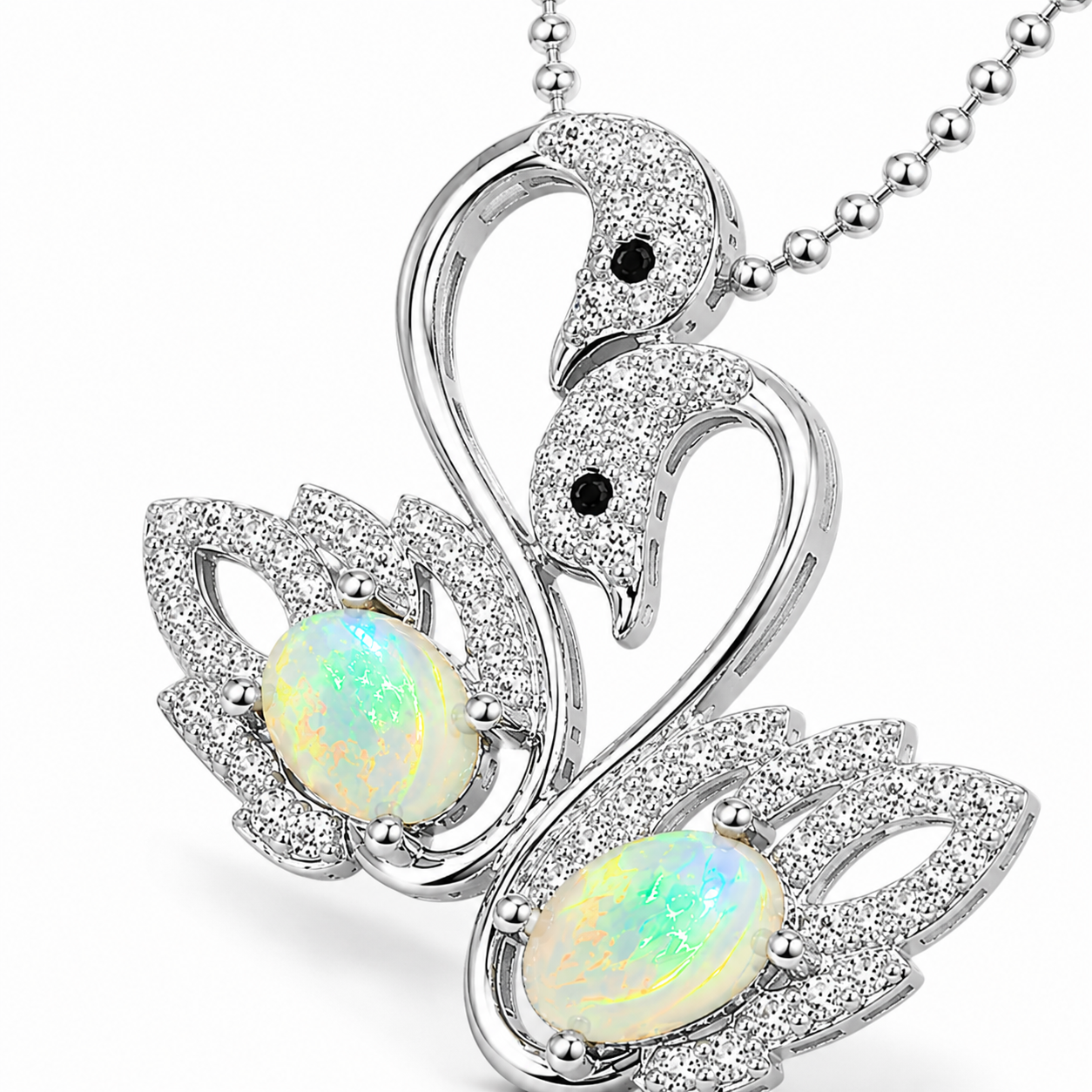 Macro close-up of 5x7mm white fire opals and sparkling double swan pendant details