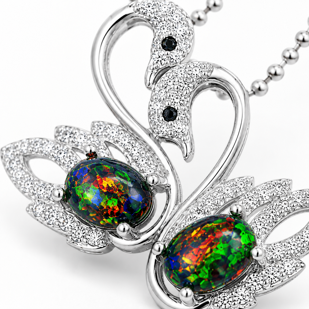 Macro close-up of colorful 5x7mm black fire opals and sparkling double swan pendant details