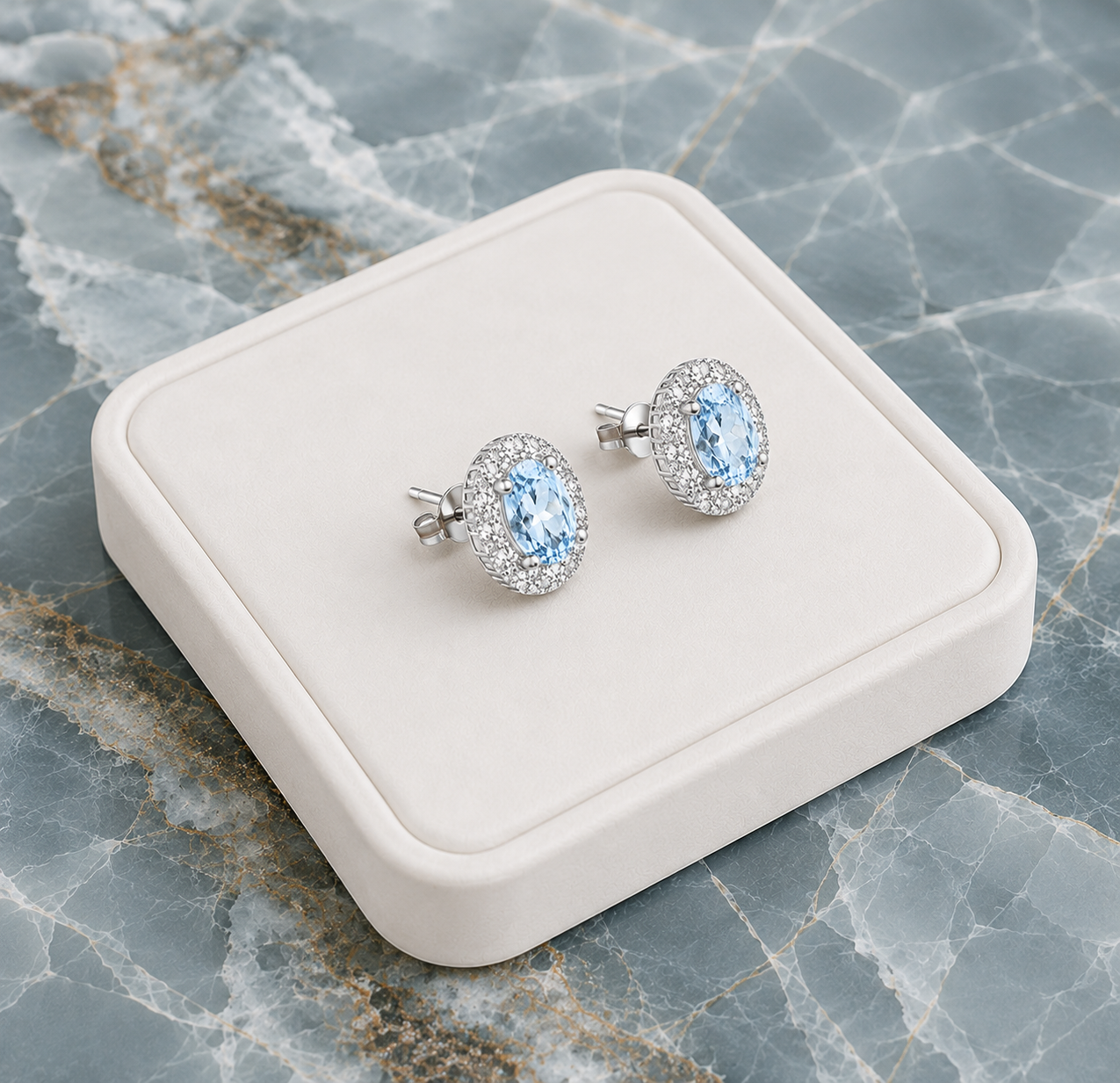 Natural Sky Blue Topaz oval halo earrings displayed on luxury white jewelry tray