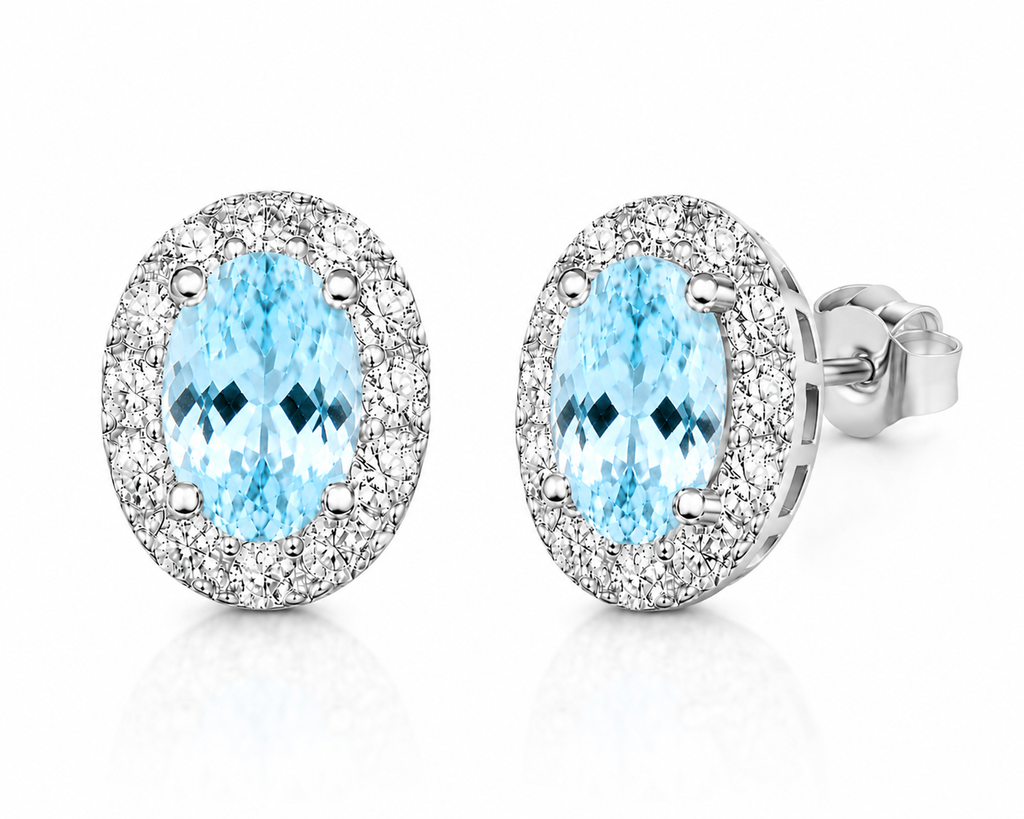 Macro close-up of natural aquamarine earrings showing blue gemstone facets and sparkling CZ halo