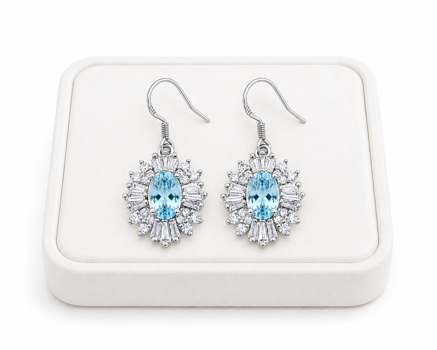 Natural aquamarine dangle earrings displayed on luxury white jewelry tray