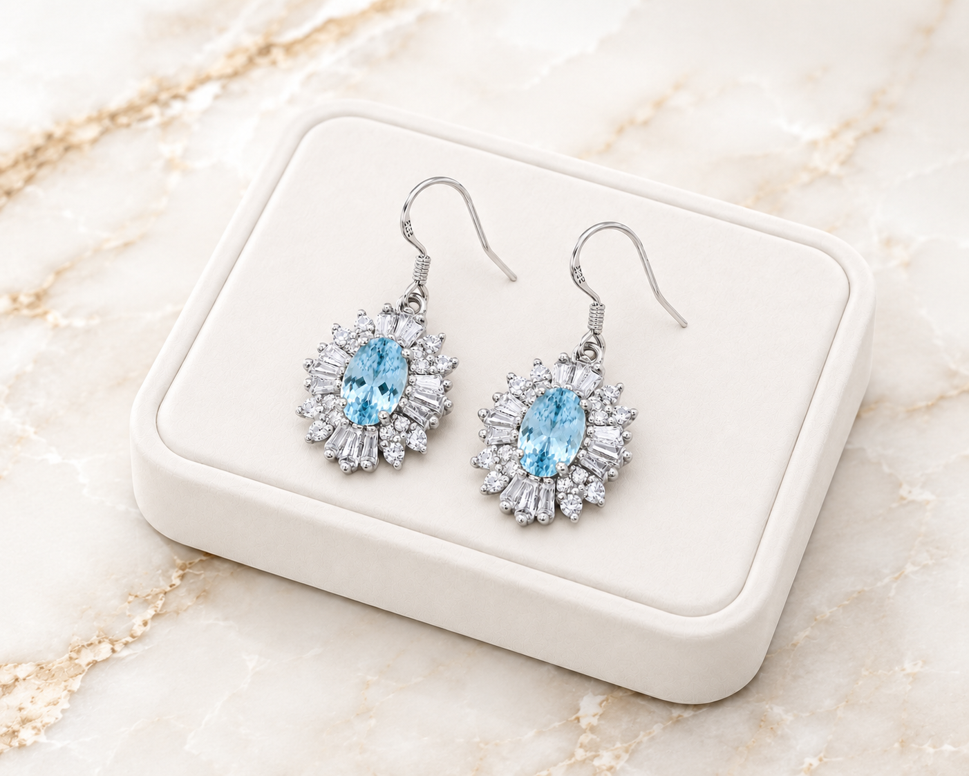 Natural aquamarine dangle earrings displayed on luxury white jewelry tray