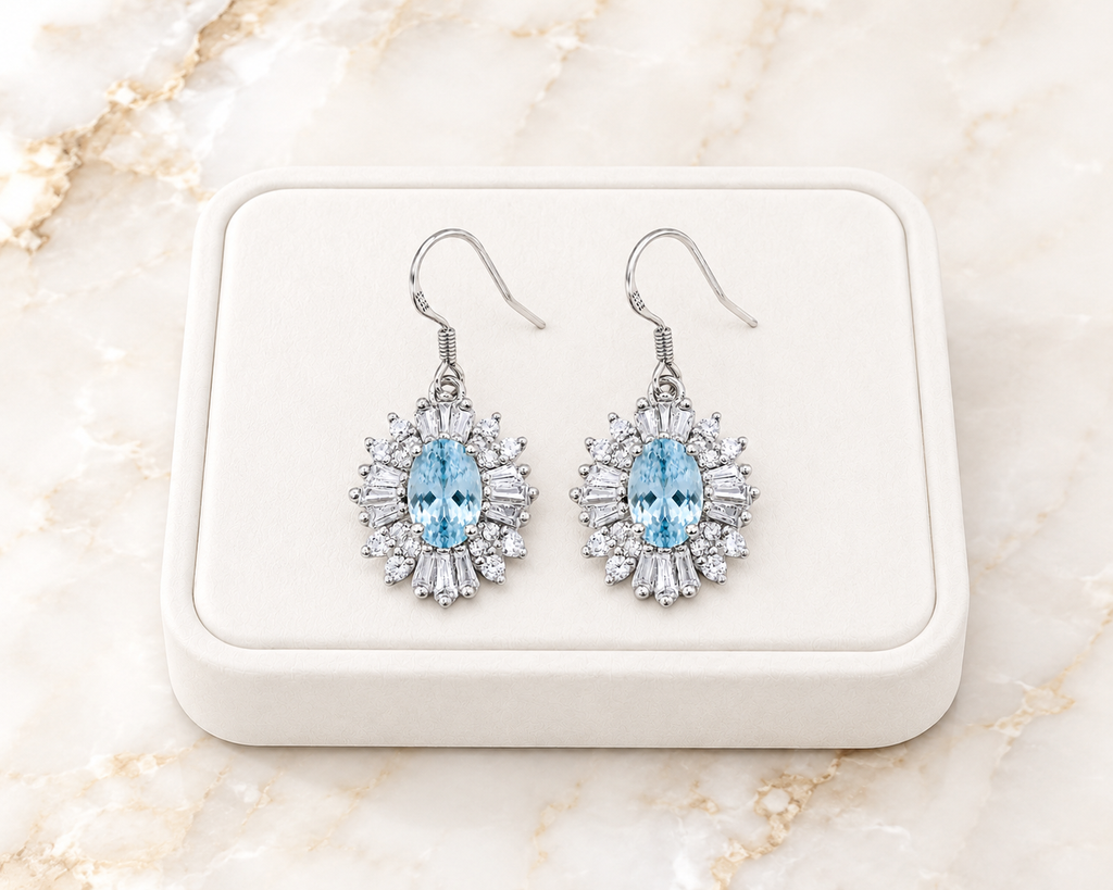 Natural aquamarine dangle earrings displayed on luxury white jewelry tray