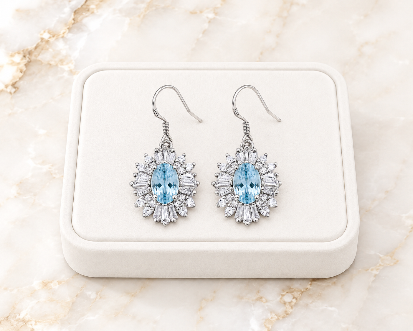 Natural aquamarine dangle earrings displayed on luxury white jewelry tray