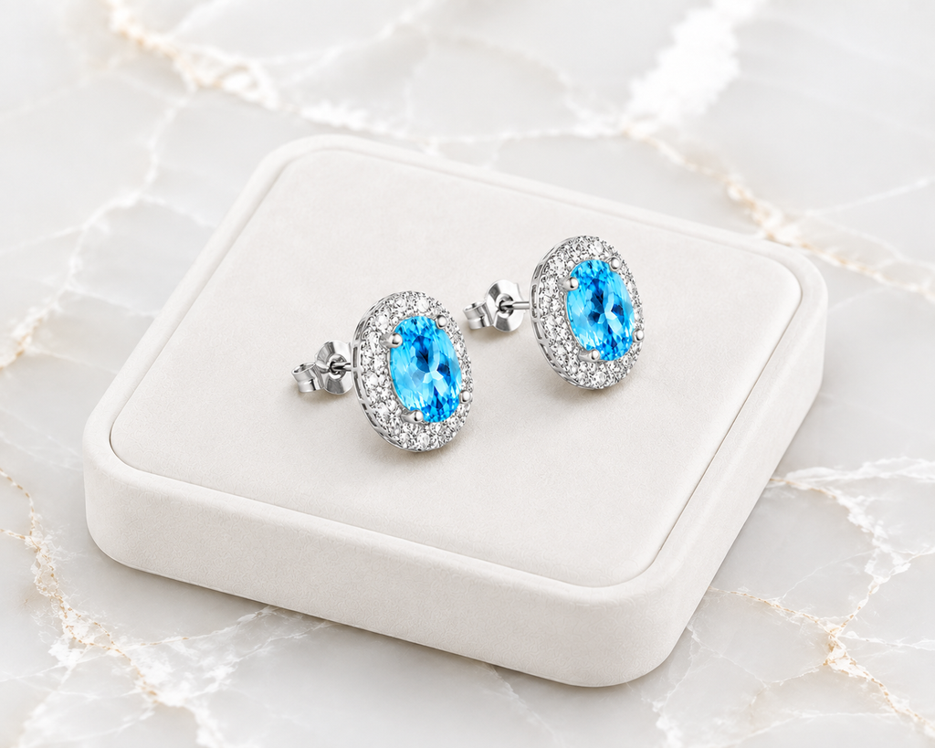 4x6mm Swiss Blue Topaz earrings displayed on a white jewelry tray over luxury marble