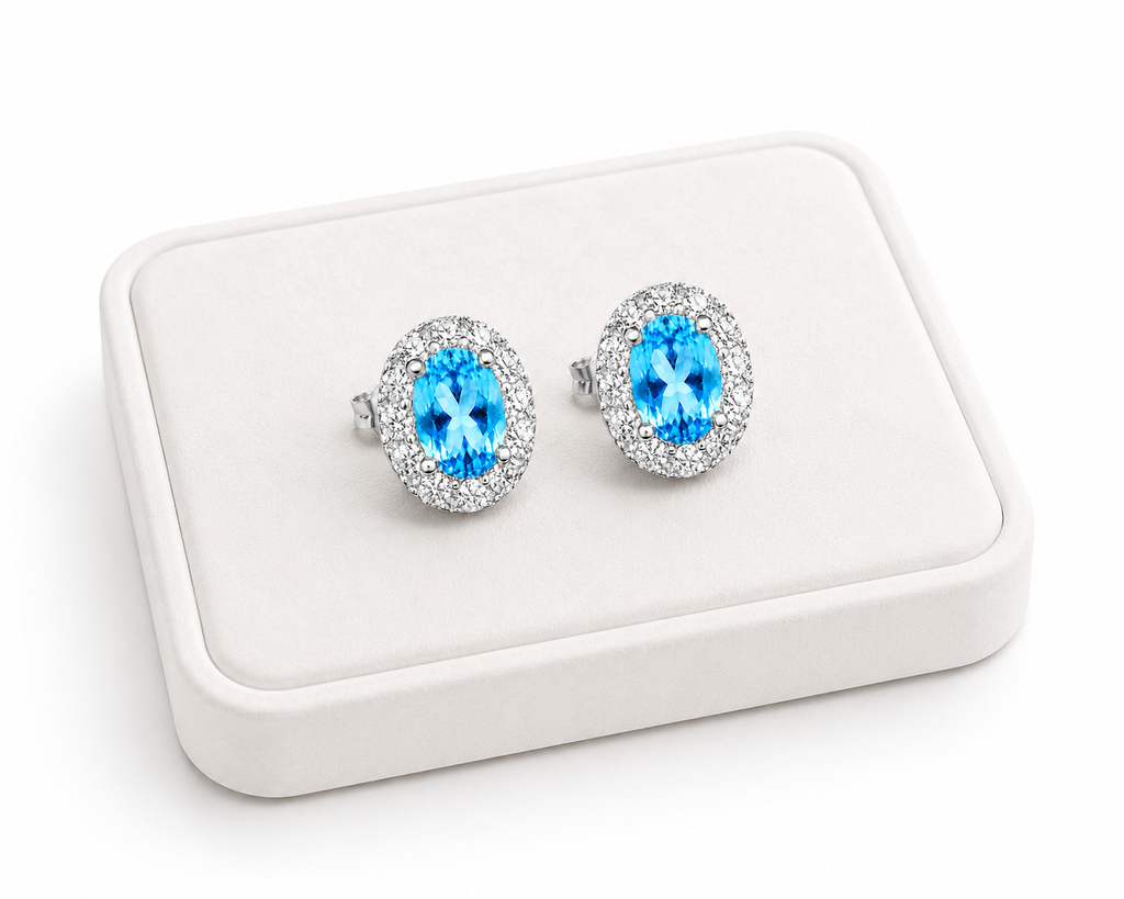 Natural Swiss Blue Topaz halo earrings displayed on a white luxury jewelry tray