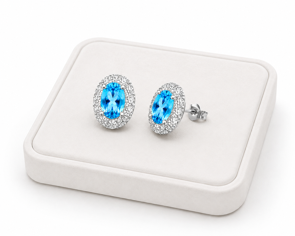 Natural Swiss Blue Topaz halo earrings displayed on a white luxury jewelry tray