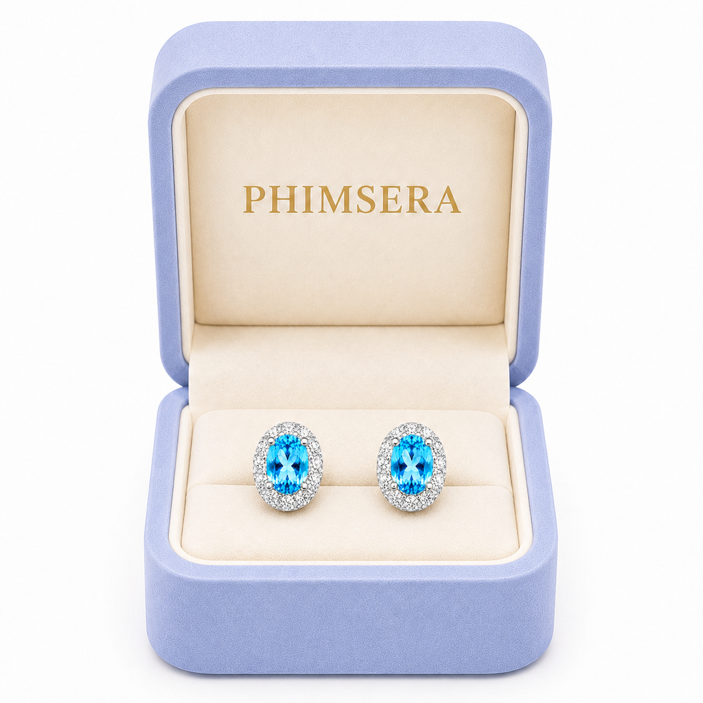 Natural Swiss Blue Topaz halo stud earrings displayed in Phimsera jewelry gift box