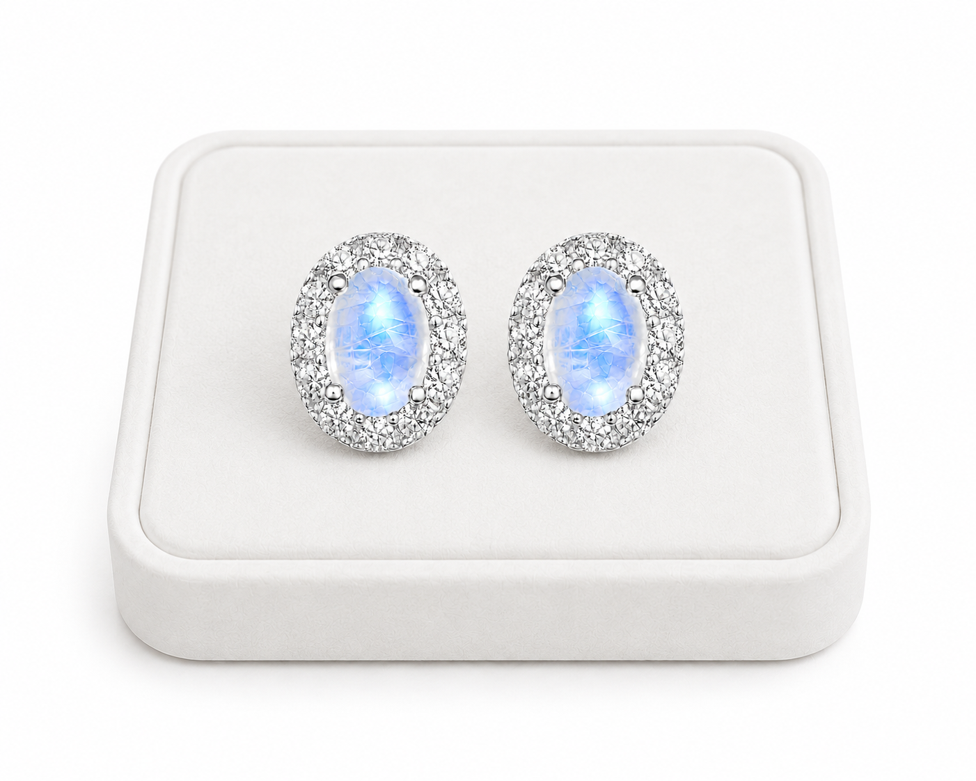 Natural 4x6mm Blue Moonstone halo earrings displayed on a white jewelry tray