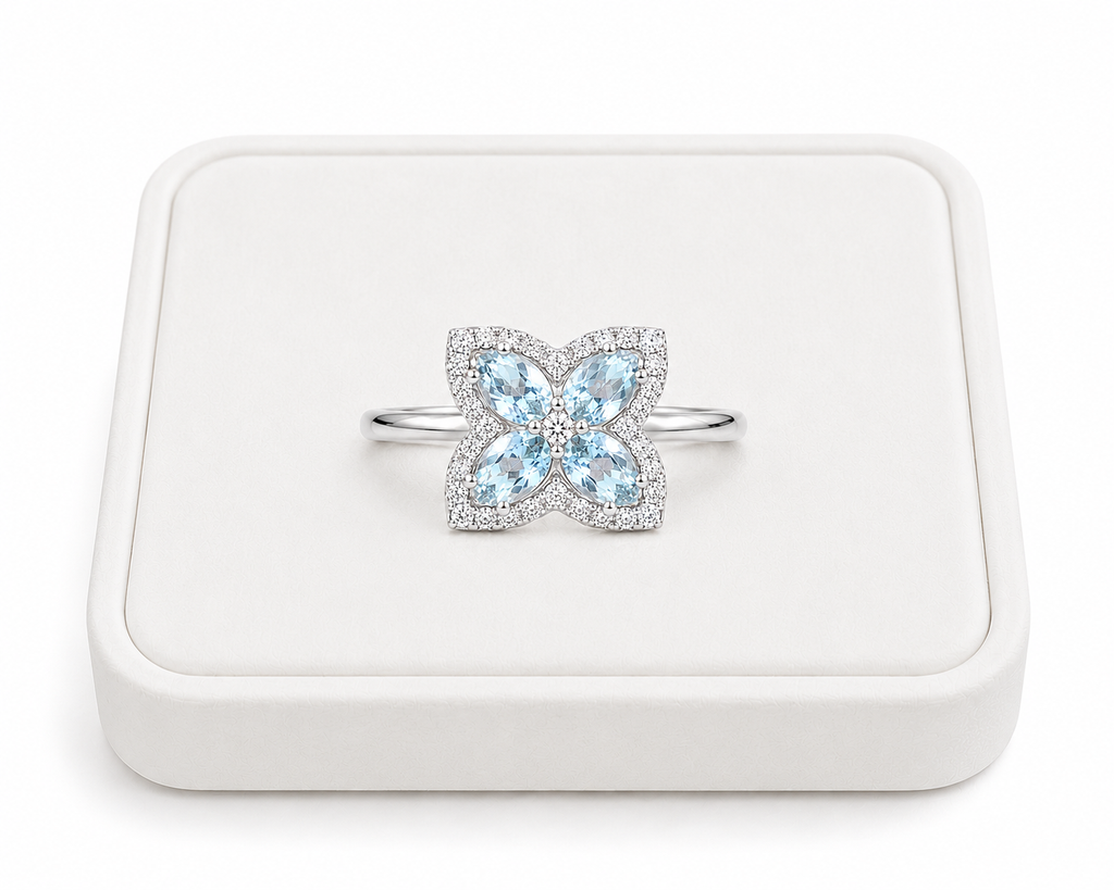 Natural aquamarine four-petal flower ring displayed on a white jewelry tray