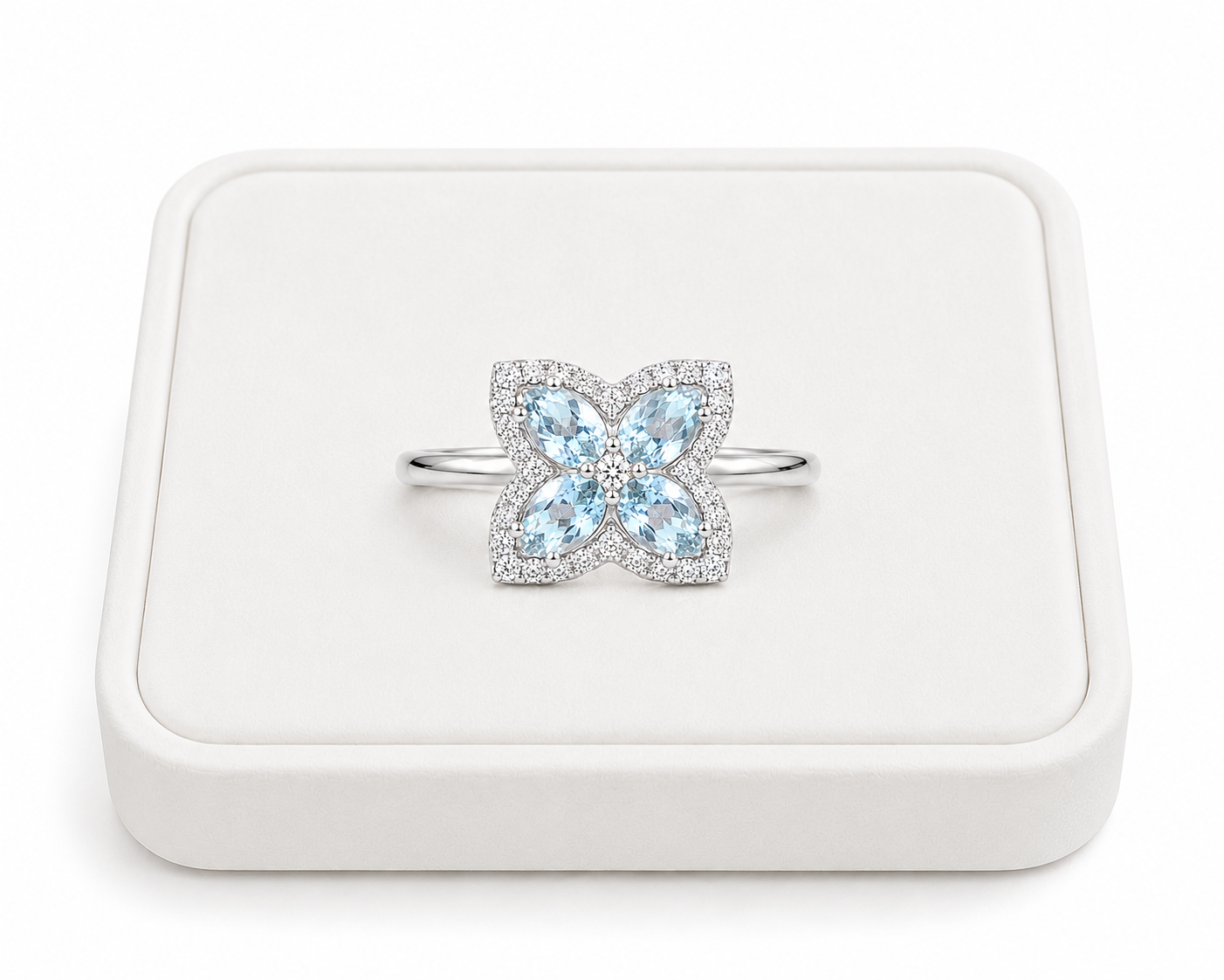 Natural aquamarine four-petal flower ring displayed on a white jewelry tray