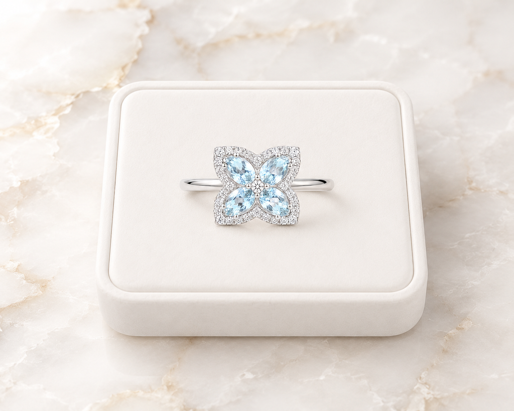Natural aquamarine floral ring displayed on a white jewelry tray over luxury marble