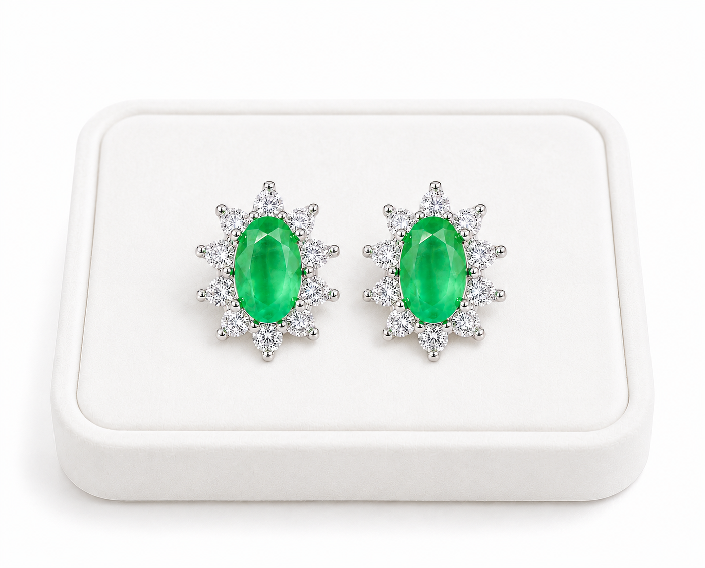 Natural emerald cluster stud earrings displayed on a luxury white jewelry tray