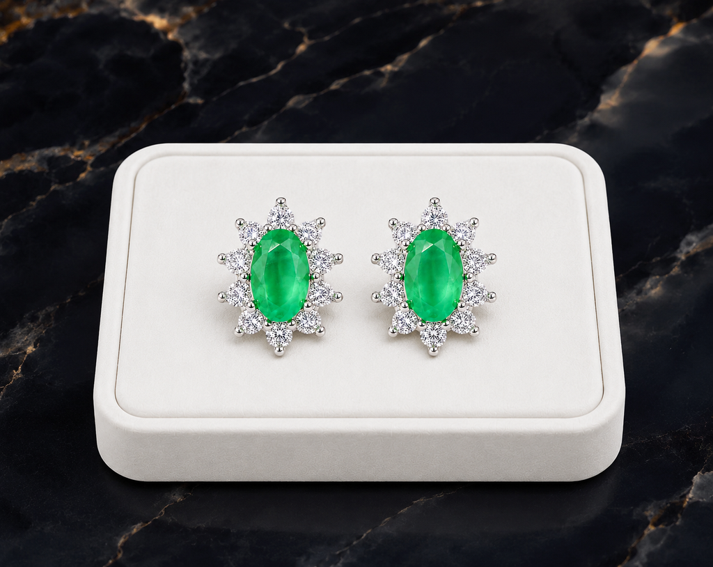 Natural emerald cluster stud earrings displayed on a luxury white jewelry tray