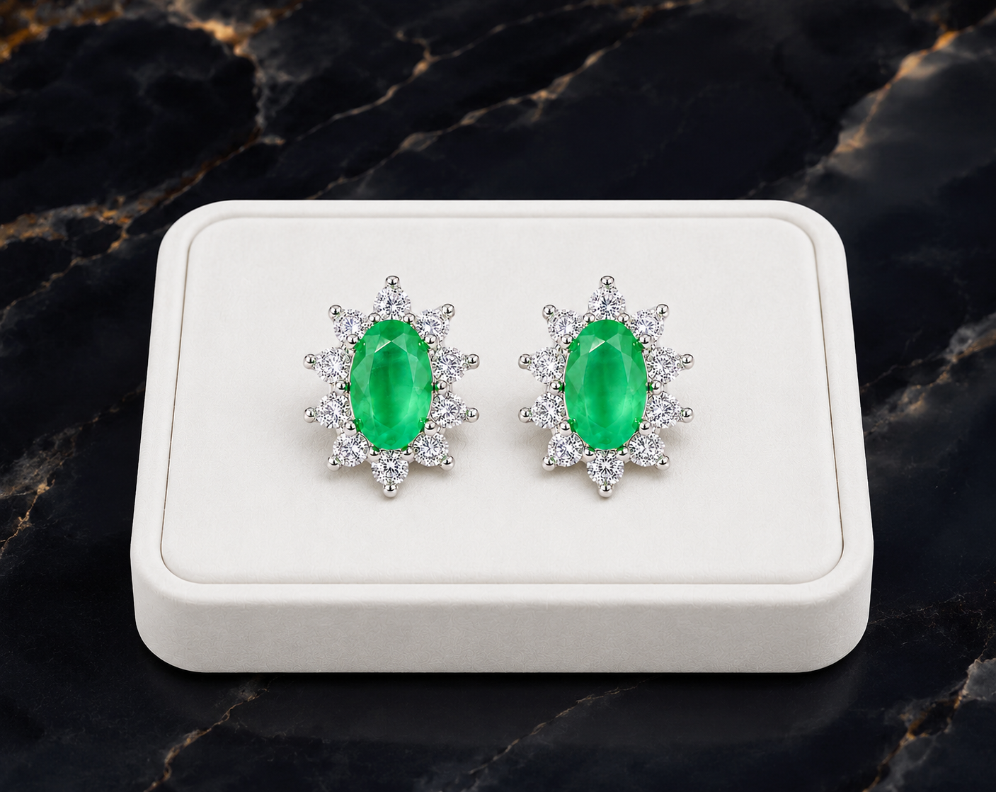 Natural emerald cluster stud earrings displayed on a luxury white jewelry tray