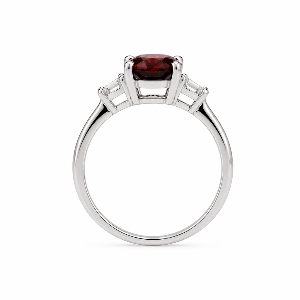 Natural 7x9mm oval red garnet solitaire ring with tapered cubic zirconia accent stones in sterling silver.
