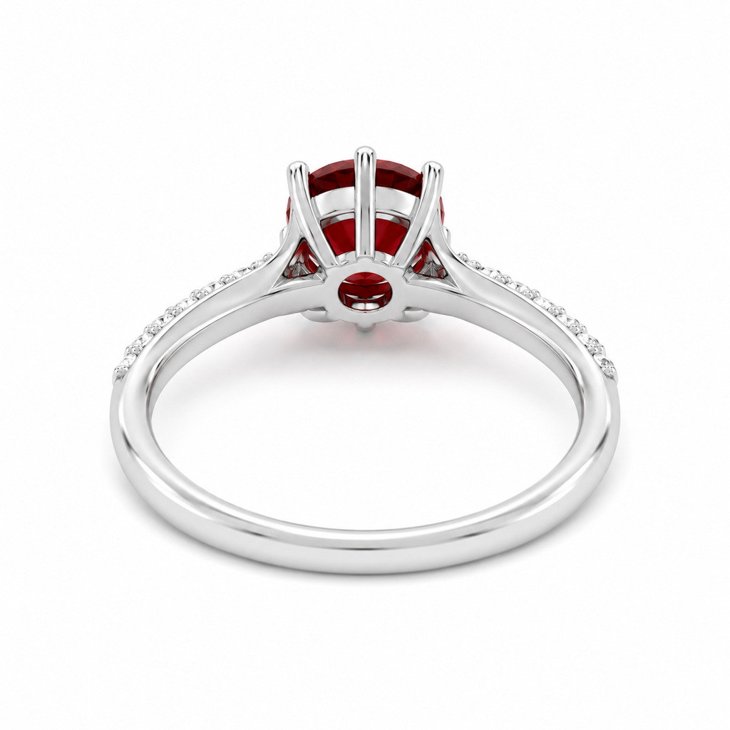 Natural 8mm round red garnet solitaire ring with cubic zirconia pavé shoulder accents in platinum plated sterling silver on a white background