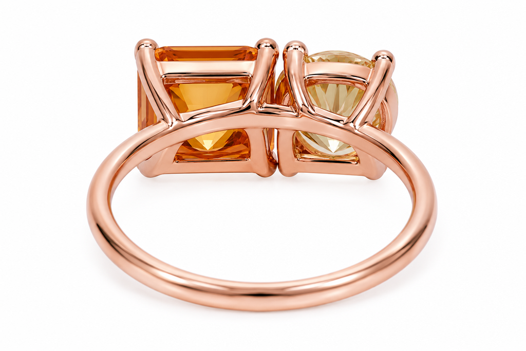 Two stone yellow moissanite ring featuring Asscher cut and round brilliant cut gemstones in rose gold plated 925 sterling silver on a white background