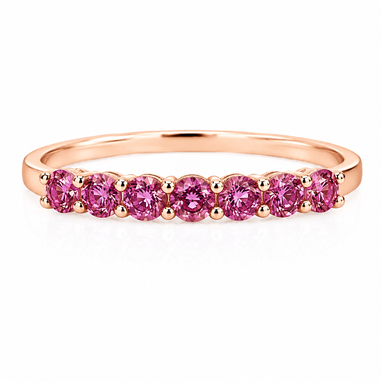 Natural Pink Garnet half eternity ring featuring seven genuine 3mm round pink garnets in rose gold plated 925 sterling silver on a white background.
