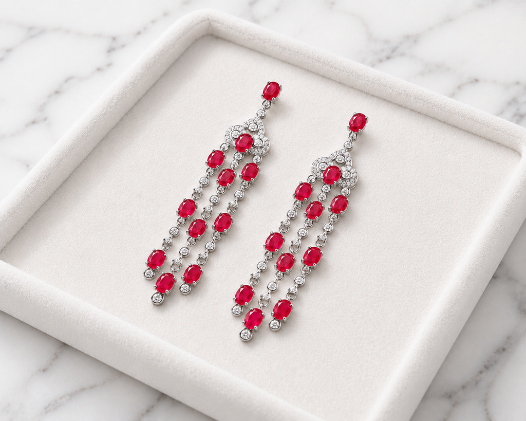 Natural ruby chandelier drop earrings featuring genuine 3x4mm oval rubies, cubic zirconia accents, and platinum plated 925 sterling silver on a white background.