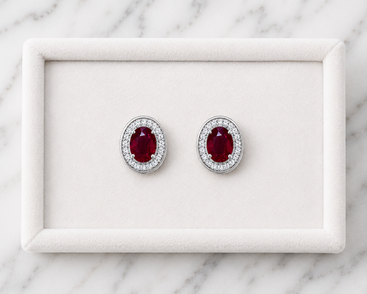 Natural 4x6mm oval ruby halo stud earrings in platinum plated 925 sterling silver with sparkling cubic zirconia on a white background.
