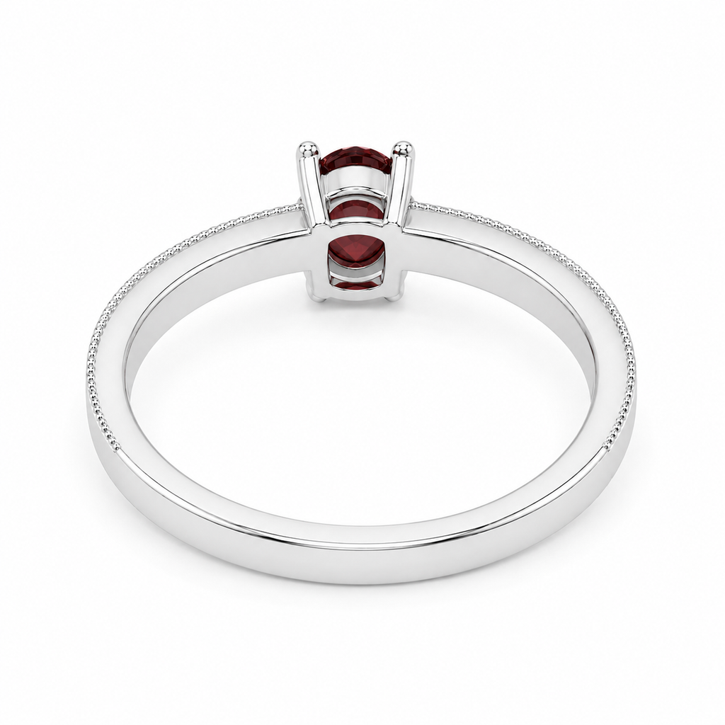 Natural 4×6mm oval red garnet ring crafted in platinum plated 925 sterling silver with vintage-inspired milgrain detailing and cubic zirconia accents on a white background.