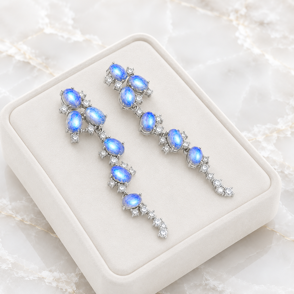 Natural Blue Moonstone stud earrings featuring genuine 4x6mm oval moonstones surrounded by high quality cubic zirconia in 925 sterling silver.