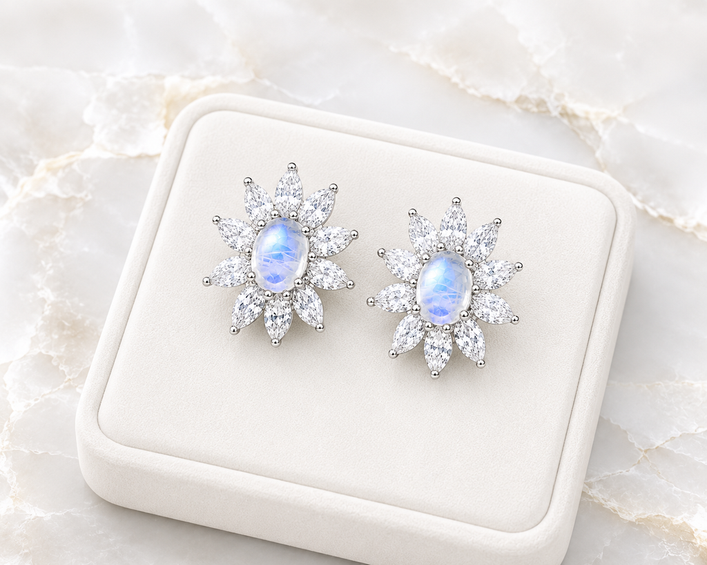 Blue Moonstone earrings displayed on a velvet tray over a marble table.