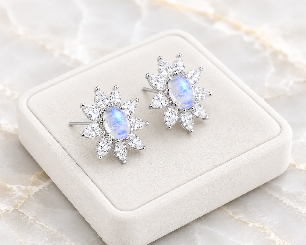 Blue Moonstone earrings displayed on a velvet tray over a marble table.