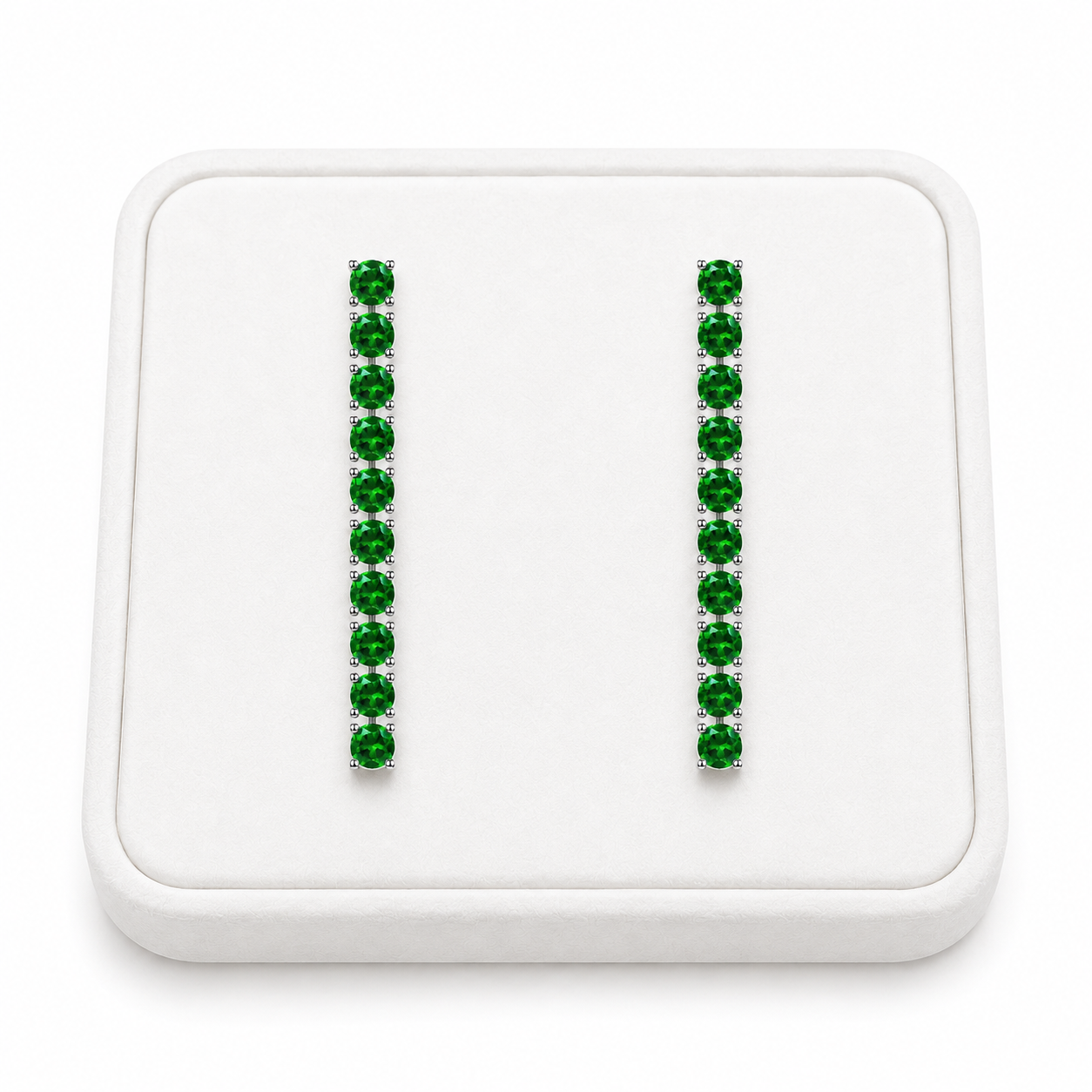 Phimsera natural chrome diopside dangle earrings displayed on a white velvet jewelry tray against a bright white background