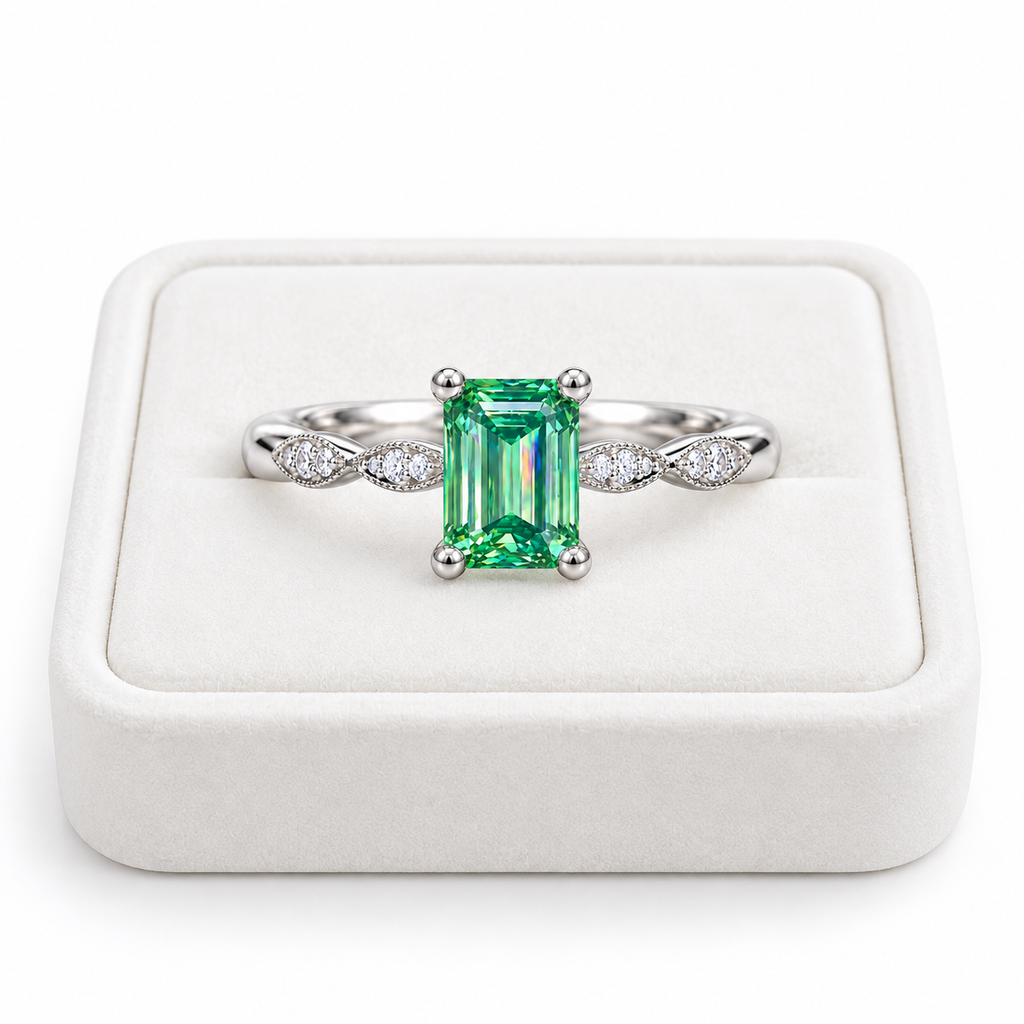 5x7mm emerald cut green moissanite ring displayed on a white velvet jewelry tray