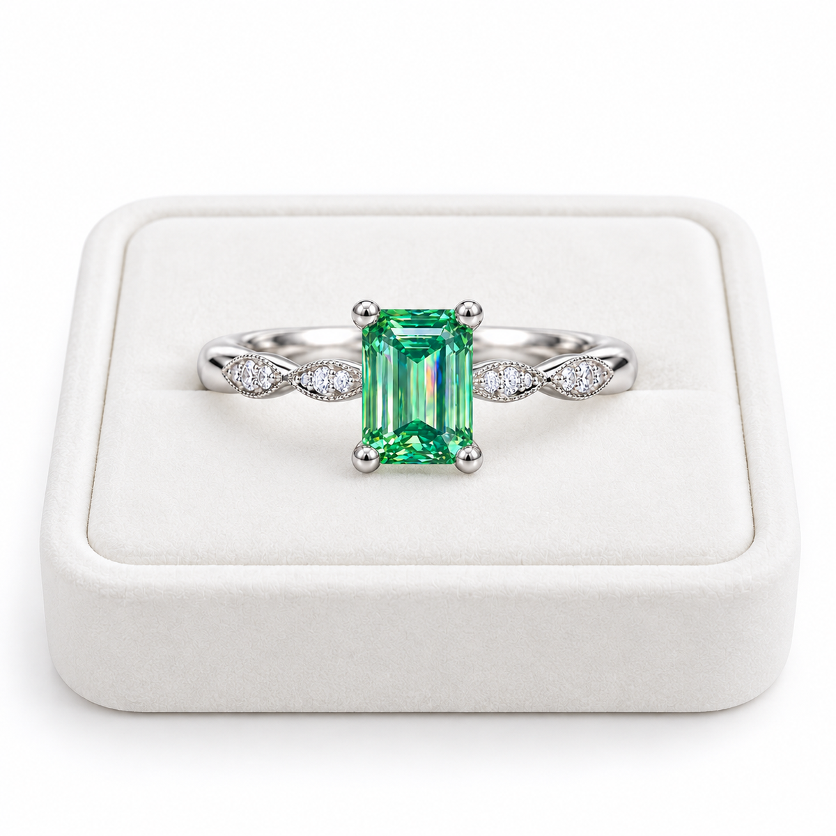 5x7mm emerald cut green moissanite ring displayed on a white velvet jewelry tray