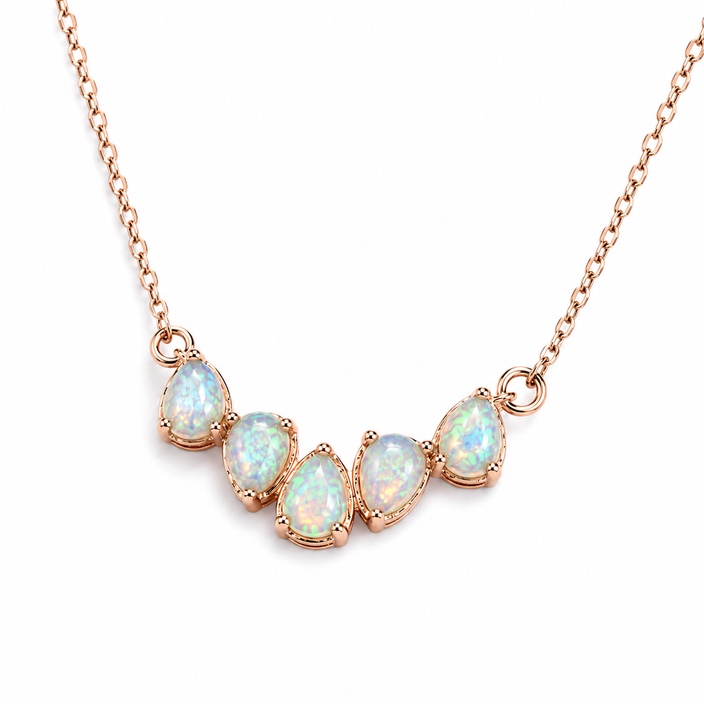Macro view of natural 3x4mm Fire Opal gemstones in rose gold settings on delicate necklace